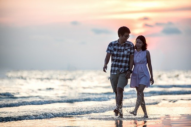 Man en vrouw die samen over het strand lopen